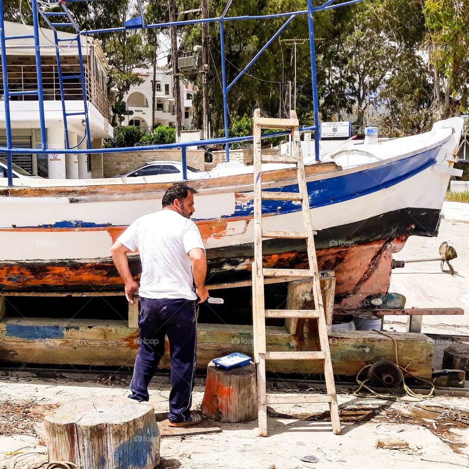 Ein griechischer Fischer streicht Dein Boot