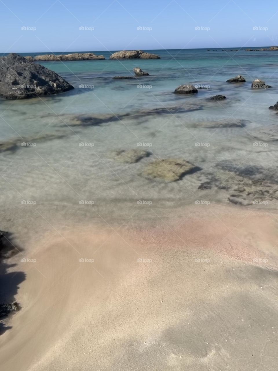 Waterfront sea,  rocks and pink sand 