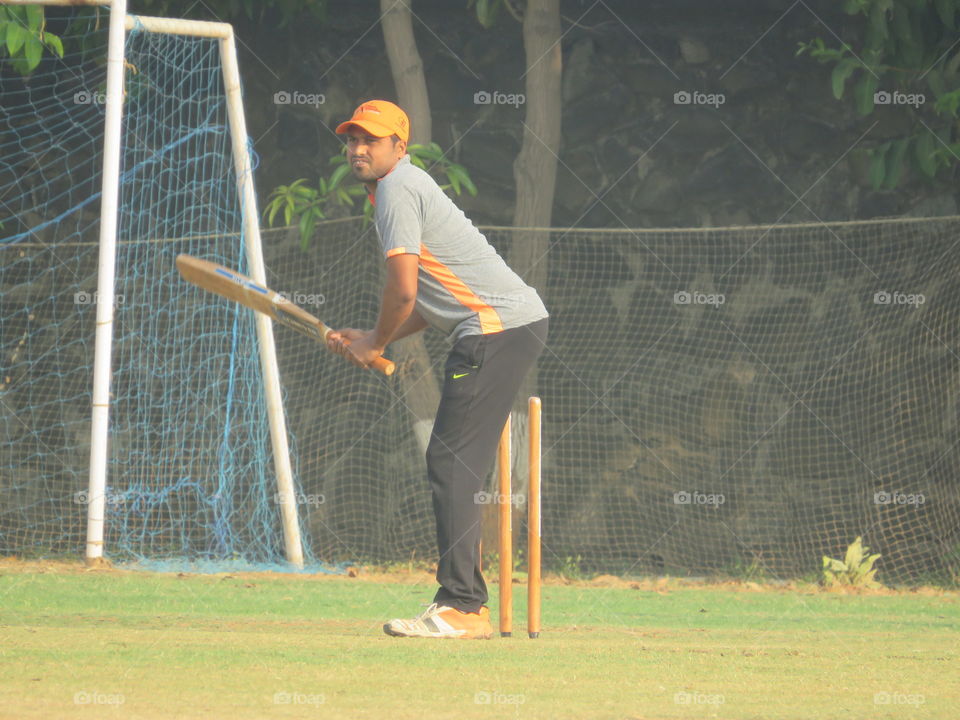 Young man playing cricket on field