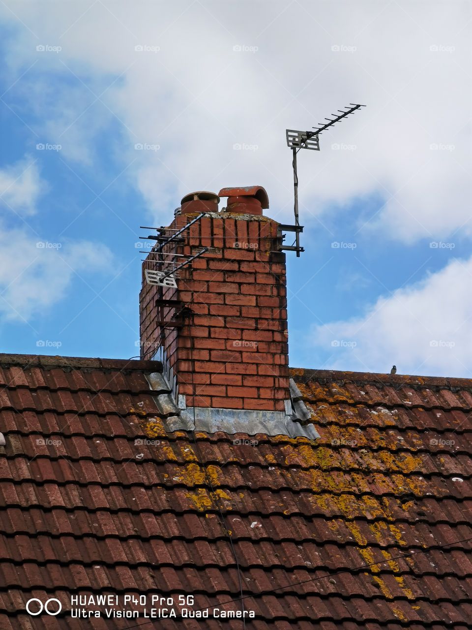 Techo de una típica casa inglesa con su chimenea y su antena.