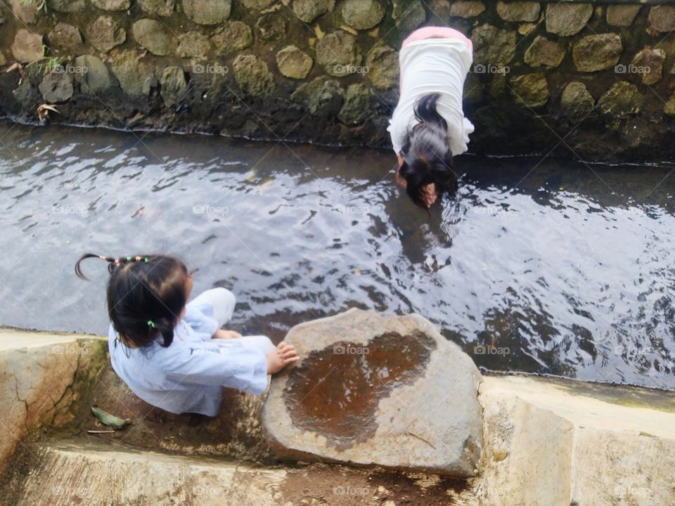 These two little children are playing in the river.