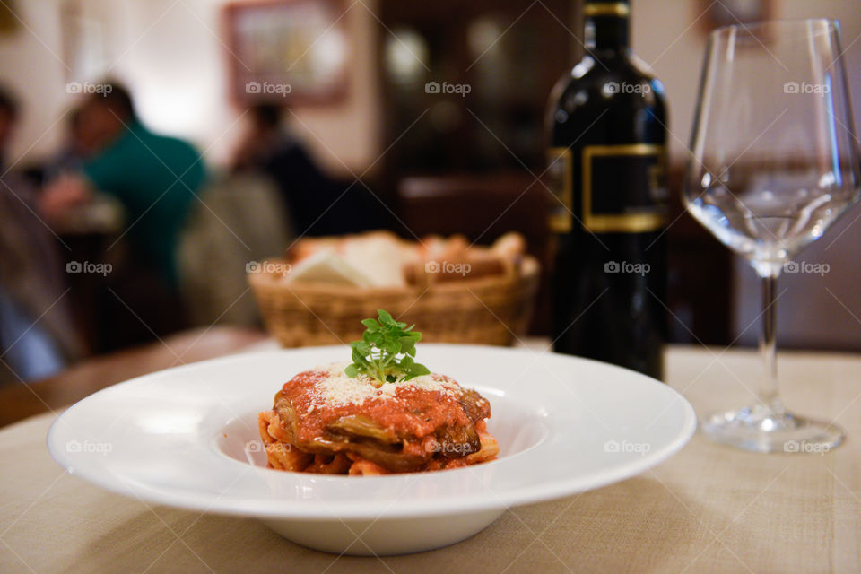Pasta dish at the restaurant in Sicily with red wine and bread.