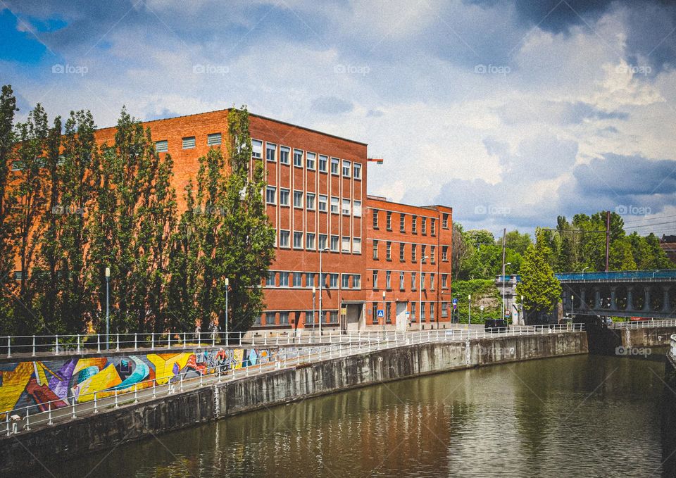 Beautiful view of the brown square buildings with European architecture located near the canal with trees growing nearby in the city of Brussels in Belgium, close-up side view. Concept beautiful urban backgrounds and wallpapers.