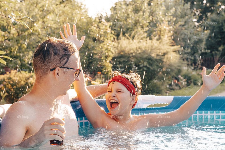 Dad and kid boy in smiling pool 