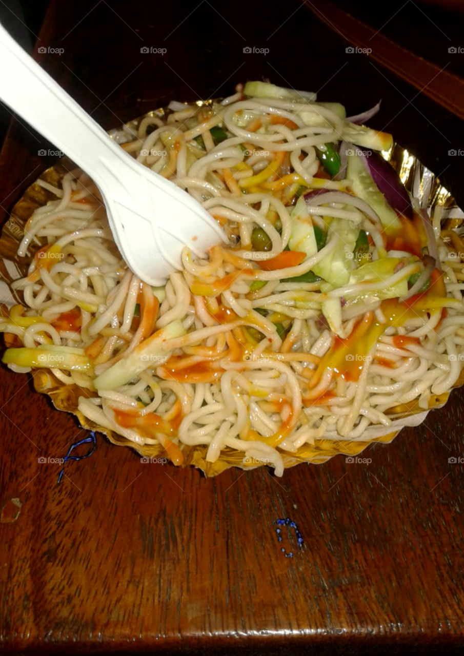 Chowmein i classic Chinese dish of stir-fried egg noodles with shredded cucumber, onion, ketchup.The most best selling streets food in India.