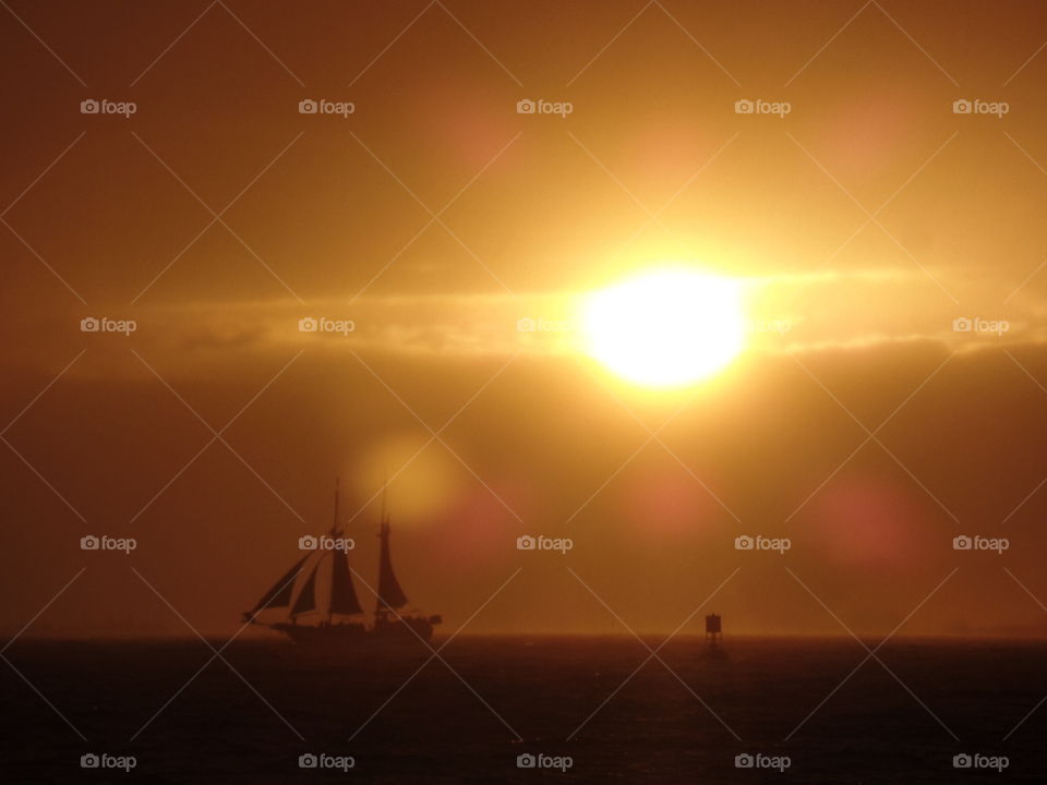 A lone ship is silhouetted under a beautiful Florida sunset