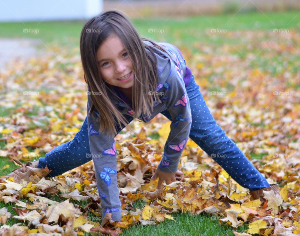 Small girl playing in autumn leaf