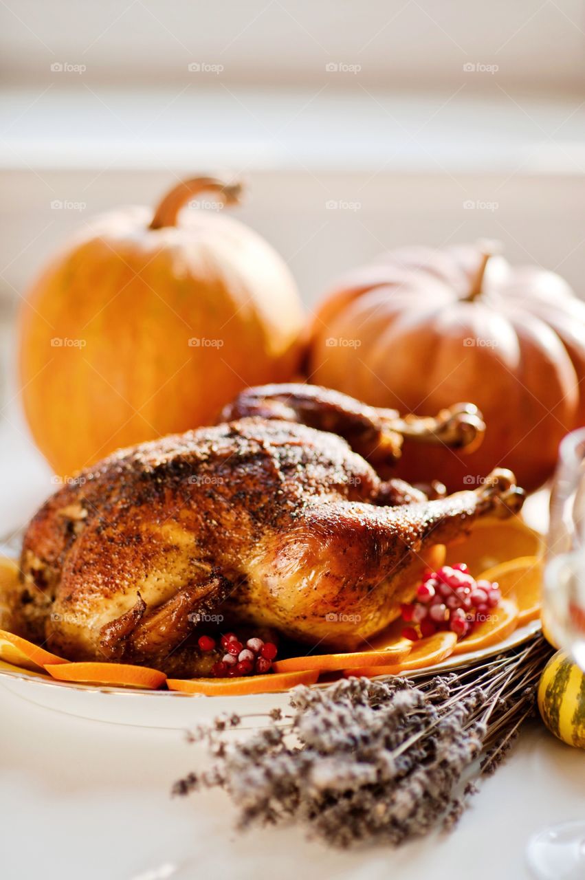 Autumn dinner from a delicious turkey surrounded by pumpkins