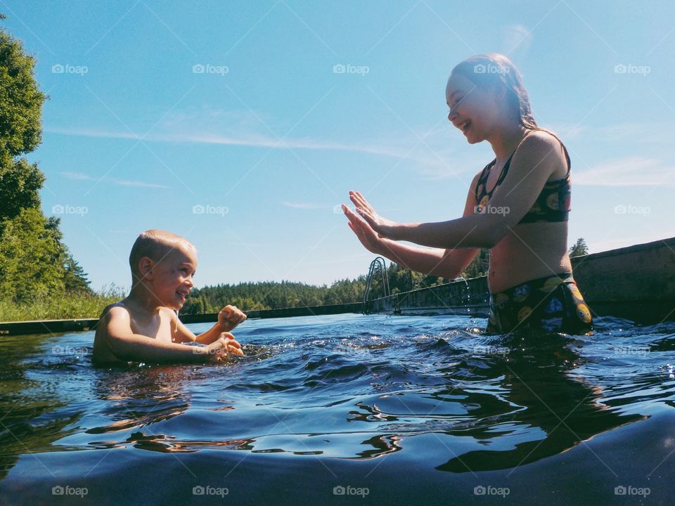 Two children having fun in the lake