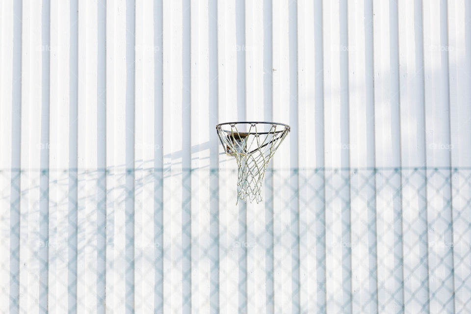 Basketball goal hoop on white wooden wall outdoors, symmetry 