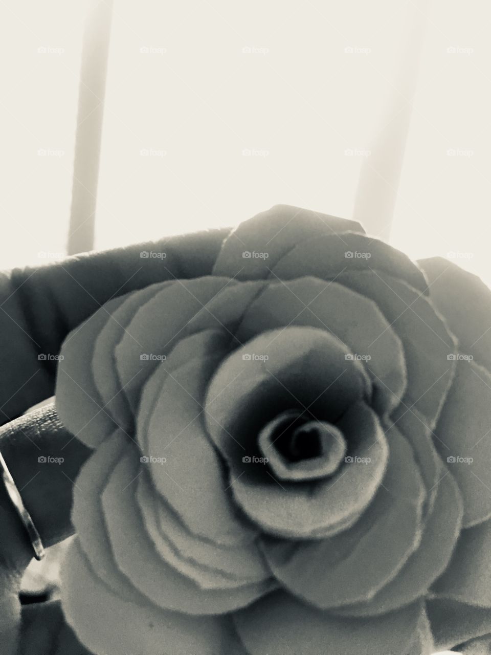 A deal and beautiful photo of a paper flower with natural lighting of open windows. The brightness of the ring draws more attention to the flower 