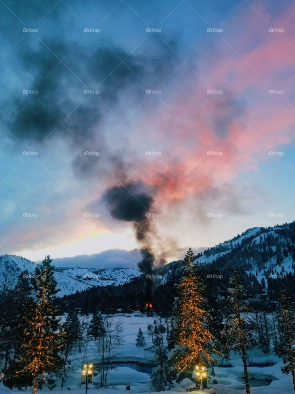 A glowing smokey sunset in the Sierra Nevada winter mountains.