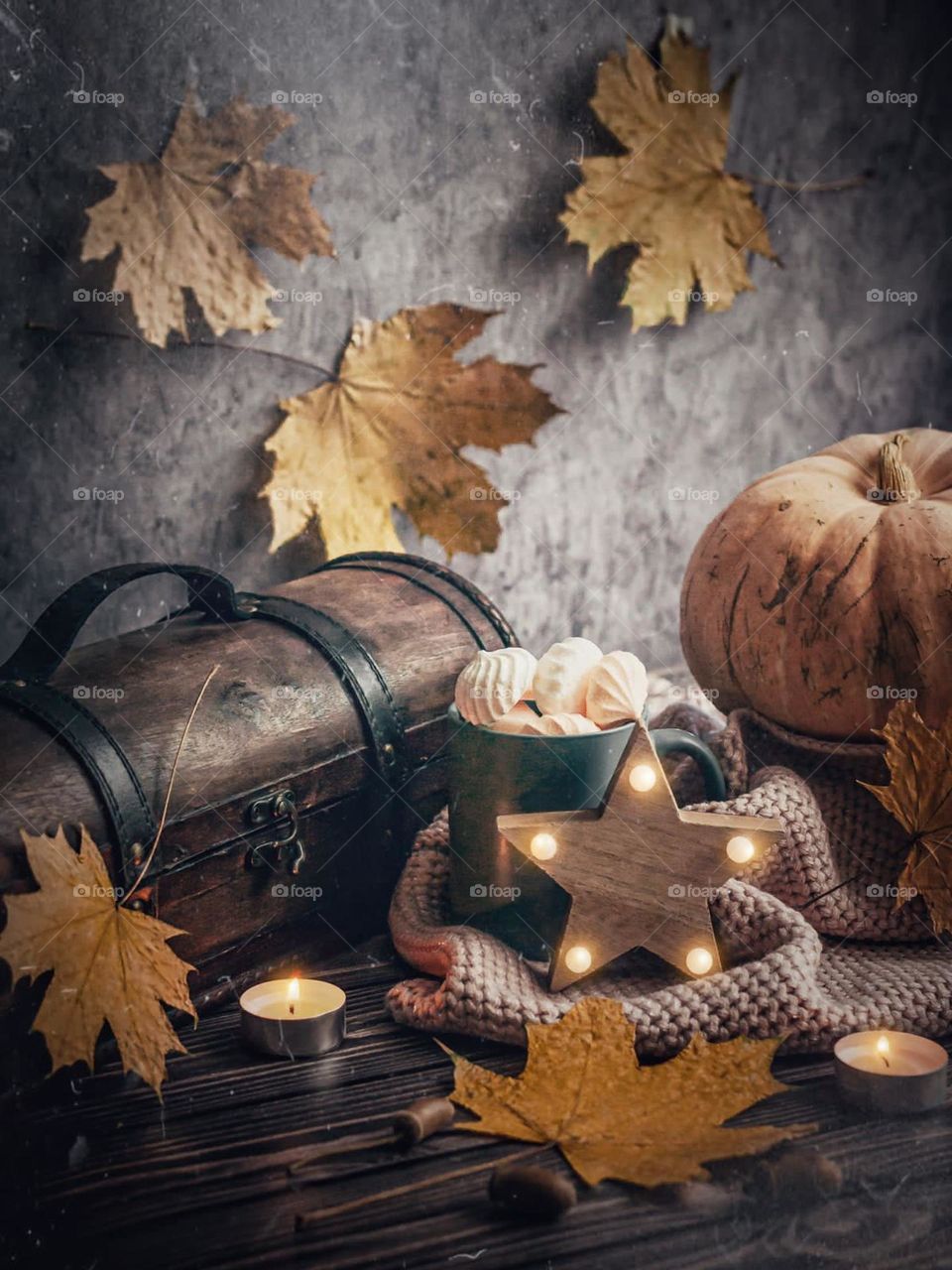 Autumn season view of halloween pumpkins on gray background with sweets and wooden chest