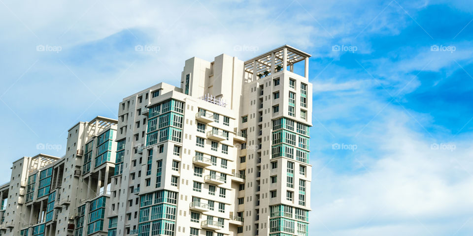 Low angle view of Modern skyscrapers Buildings in Kolkata City. Sunlight reflection, blue sky and white Fluffy clouds during sunset. Directly below view. Slanted, Tilt, diminishing perspective, Copy space room for text.