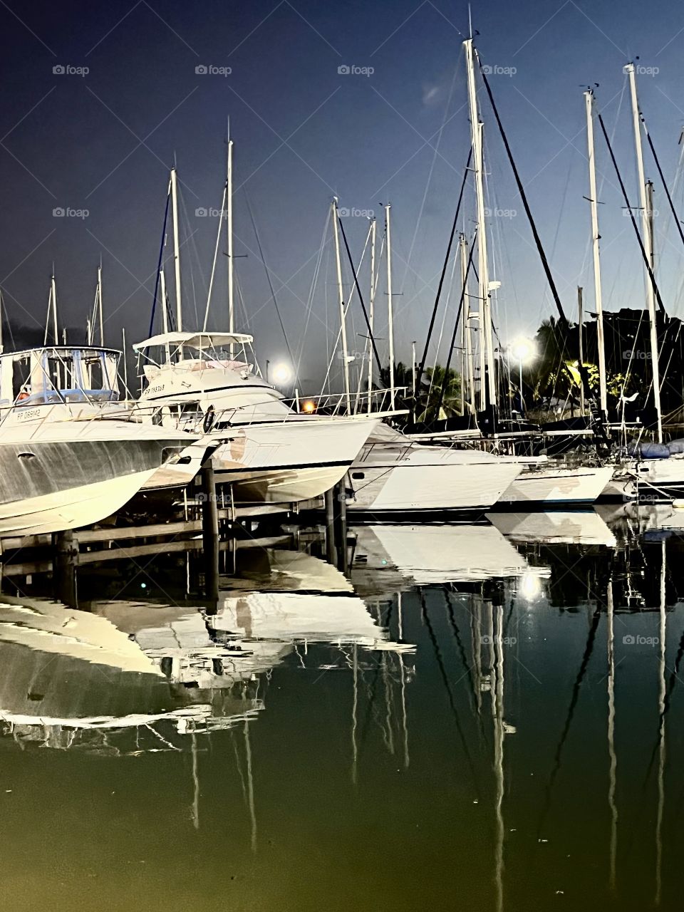 Marina night view with the reflections of boats on the water