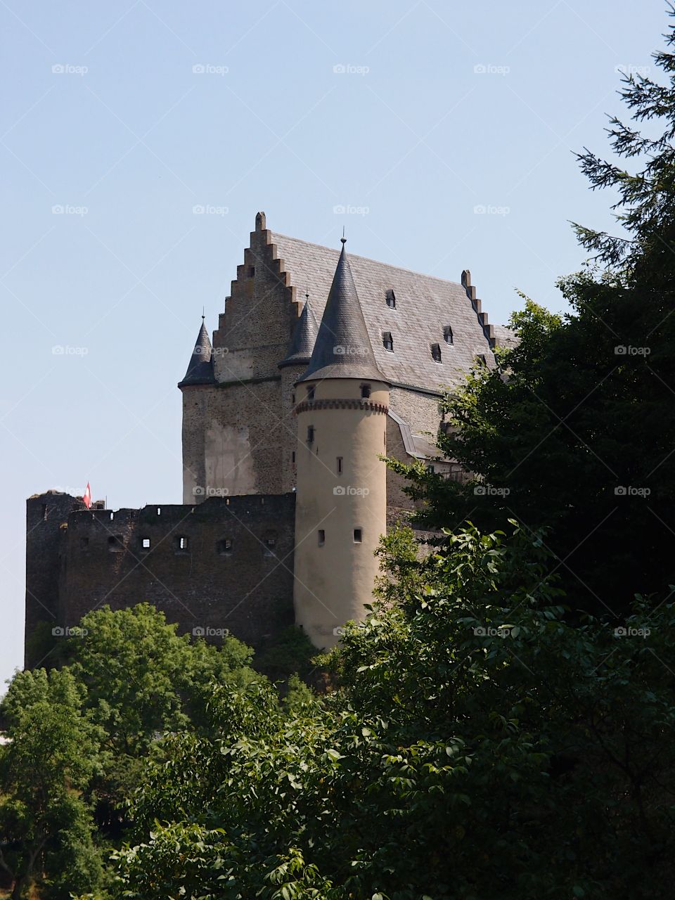 A beautiful view through the trees of Chateau dé Vianden in Luxembourg on a sunny summer day. 