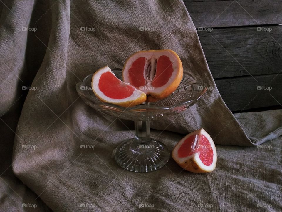 разрезанный грейпфрут в стеклянной вазе