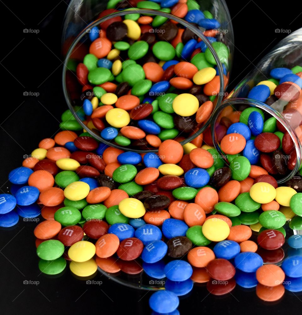 M&Ms spilling out of two glasses 