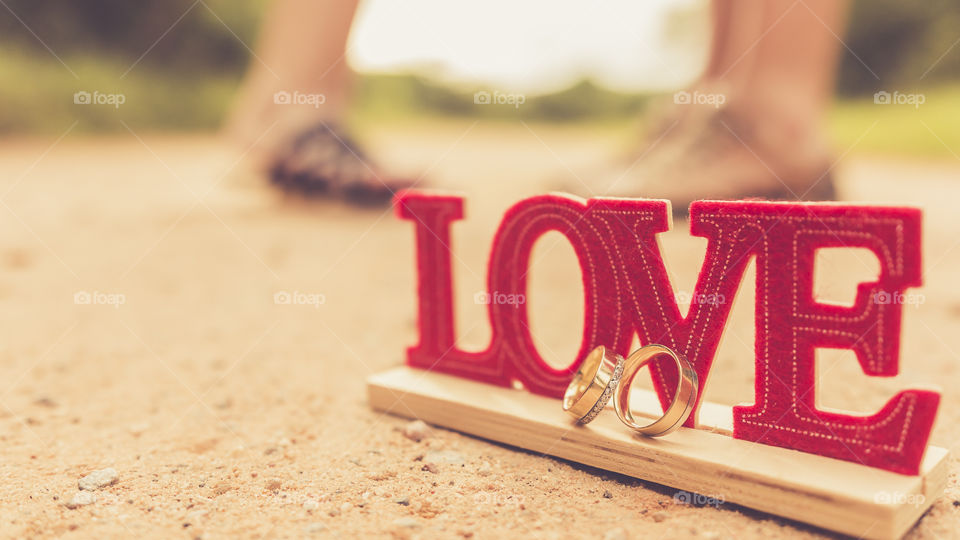 Love wooden text with two wedding rings