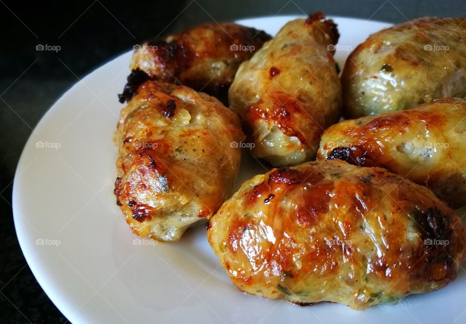 Sheftalia : Cypriot Lamb and Pork Sausages.  Traditional Cypriot food. Grilled sausages on white plate.