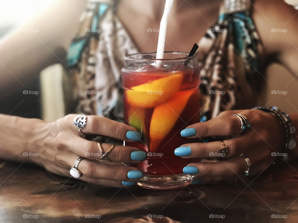 Young woman drinking colorful tropical cocktail 