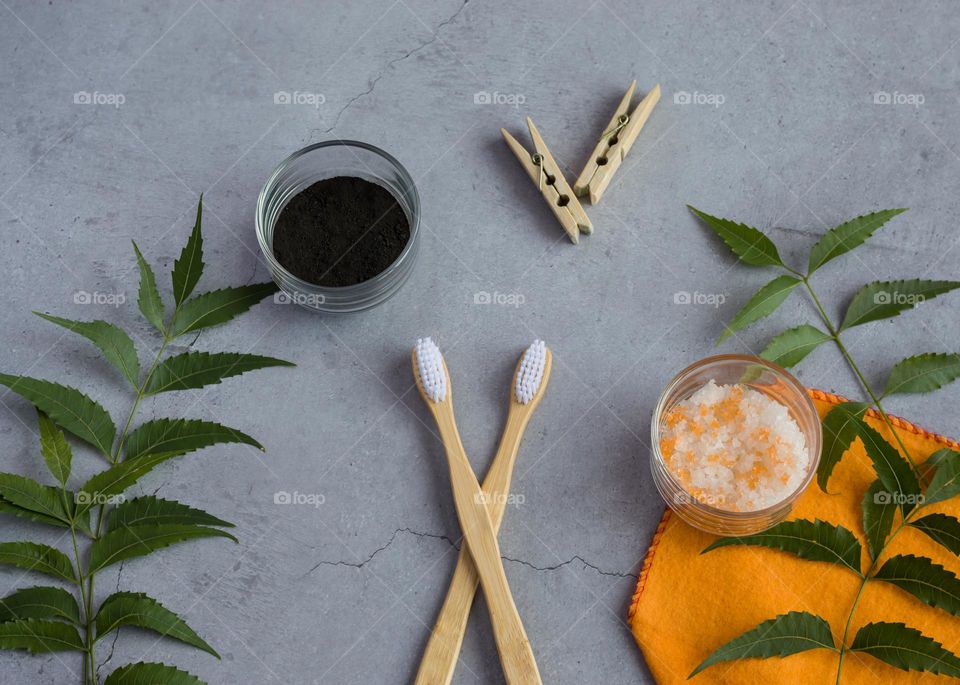 Wooden toothbrush, charcoal toothpowder, rock salt, wooden cloth clip isolated on grey background.