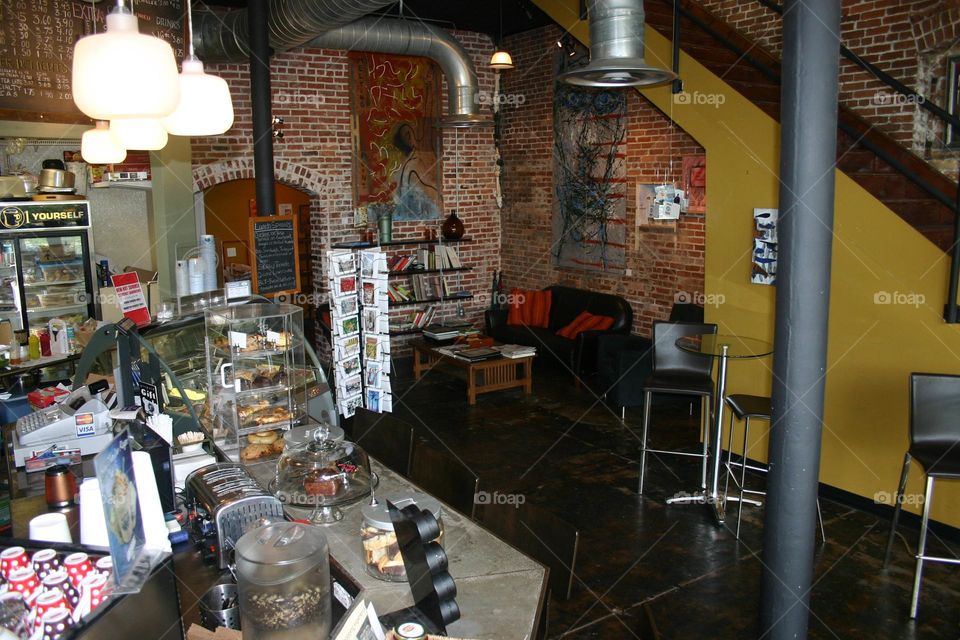 Coffee shop performance corner in background high top tables sofa brick walls