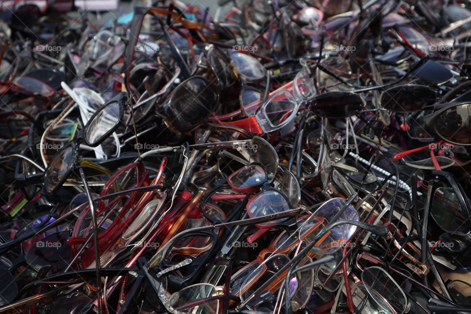 a lot of old glasses on the heap. Heap of old eyeglasses. Heap of scratched and broken eyeglasses. Repairing and replacing old eyeglasses, eye care