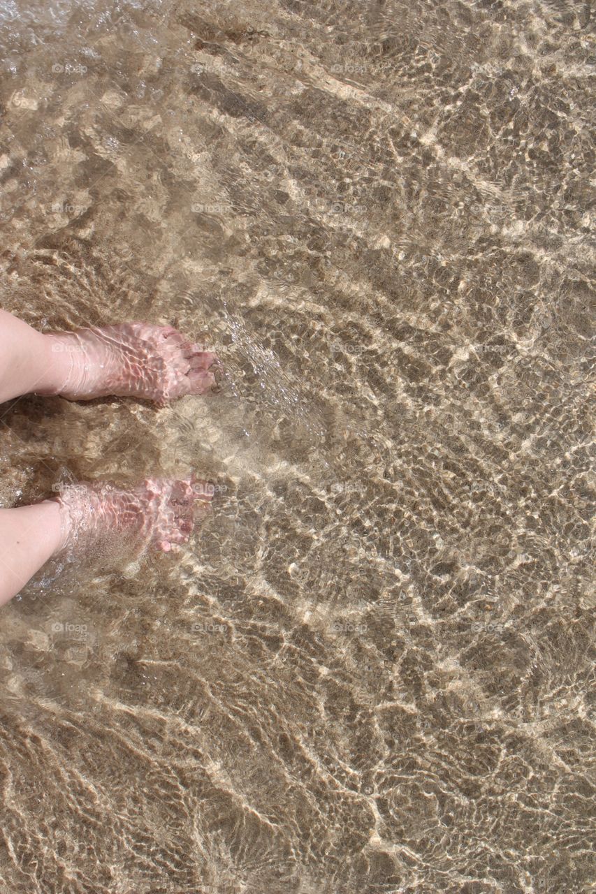 Feet sand ocean water