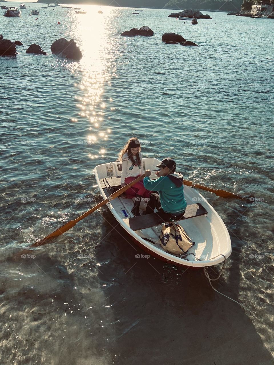 A time before technology took over children’s lives. Two children enjoying the afternoon sun in a rowboat,
