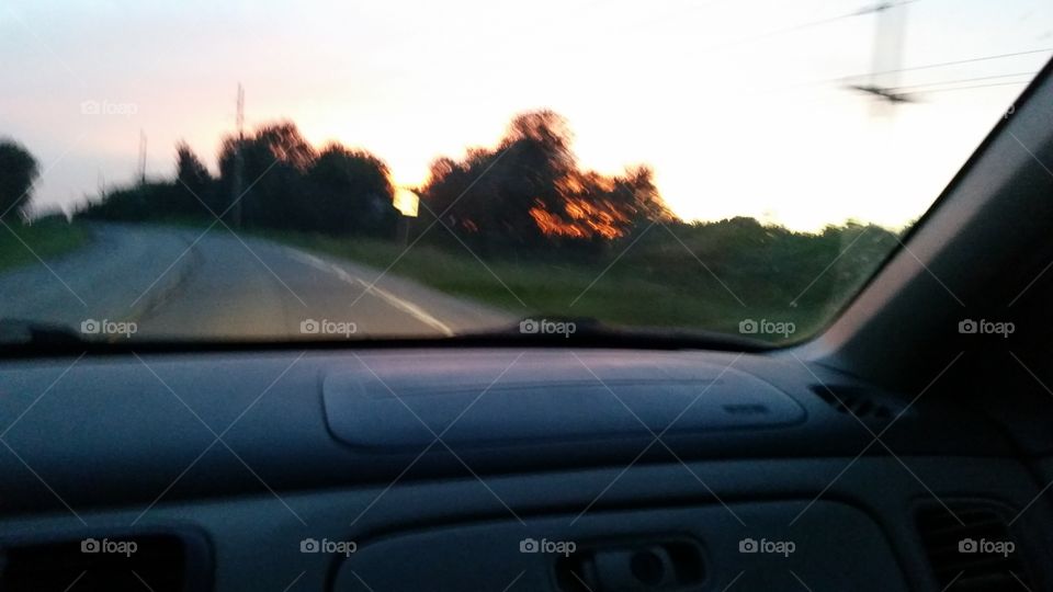 Driving blurred sunset. Driving through the country with a blurred view of a sunset