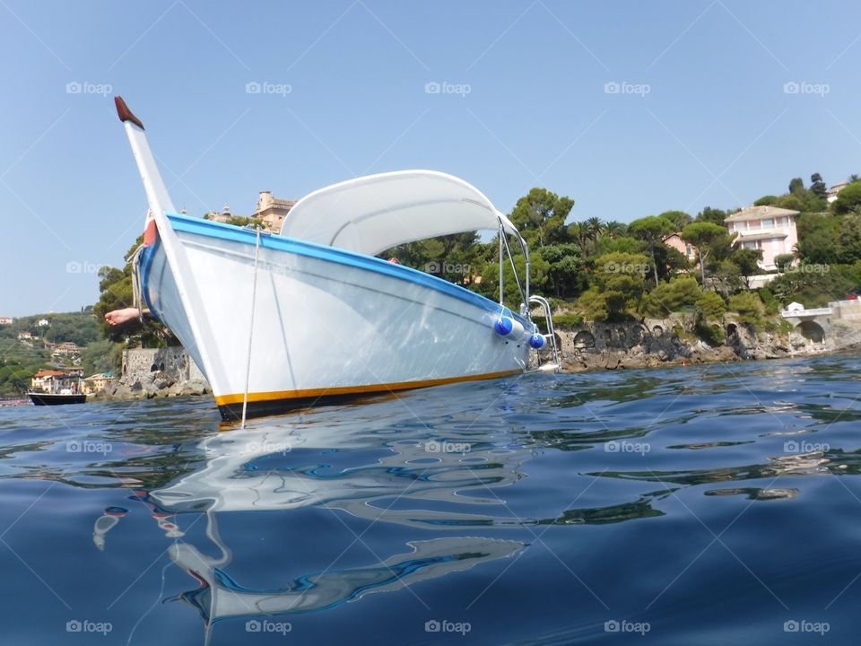 Gozzo ligure in rada. Famosa barca ligure " il gozzo" nei suoi colori originali vista dal pelo del mare
