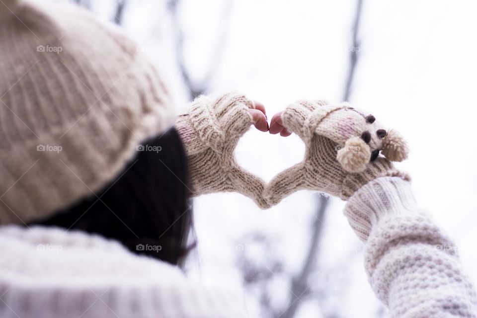 Woman shows a heart symbol with her fingers