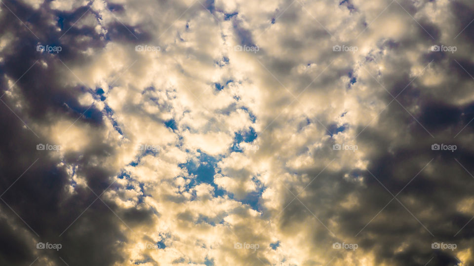 Large clouds float across the sunset sky like sails.