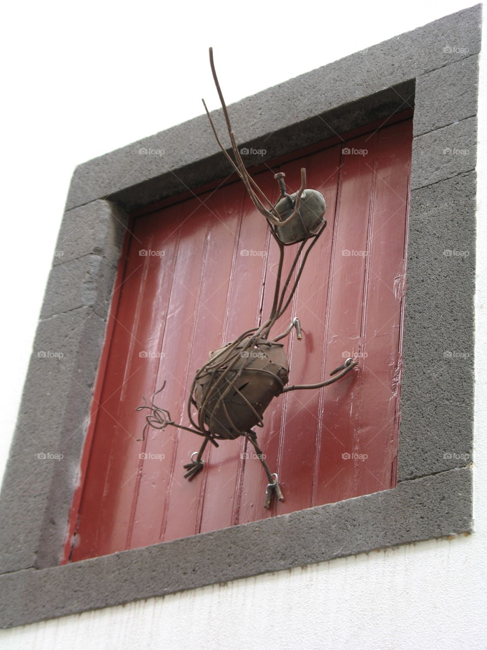 Fenêtre ornée d'une fourmi en fer forgé