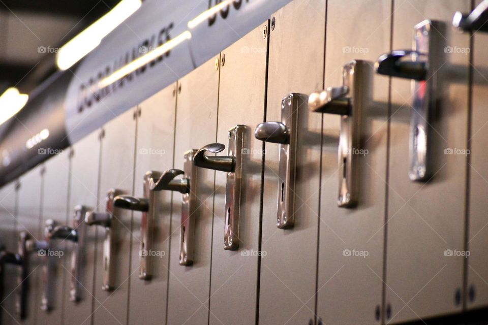 Multiple steel door handles displayed in a row