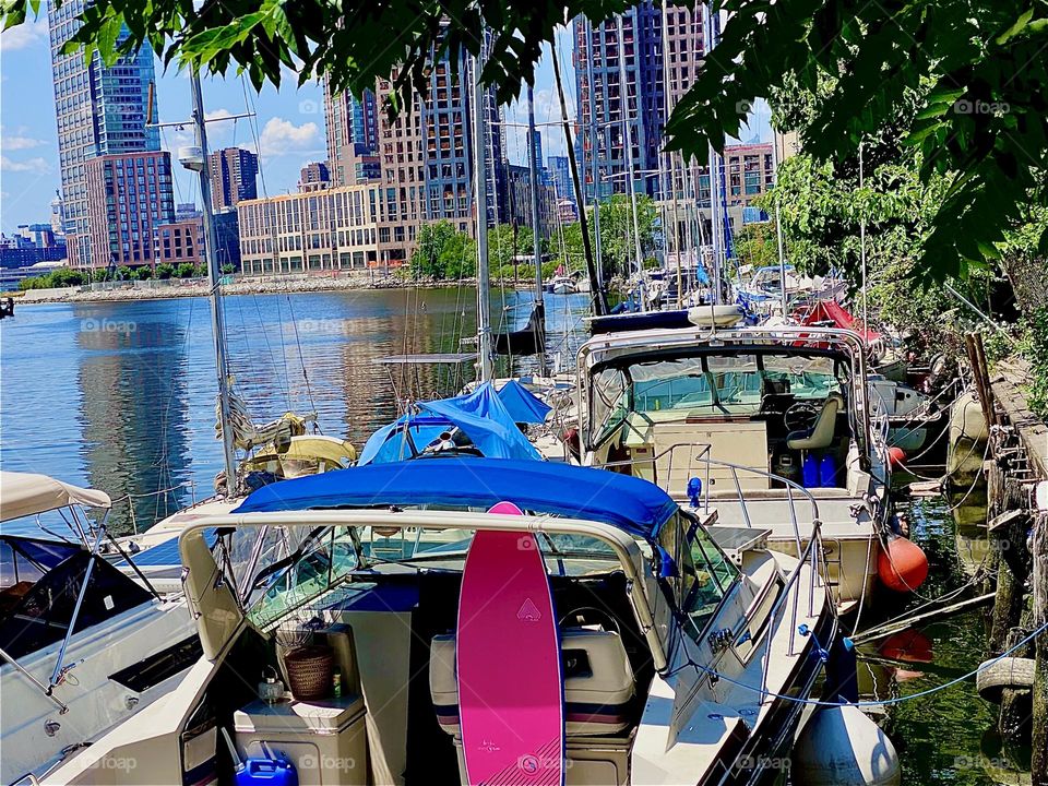 This is a beautiful idyllic tree lined view of „Newtown Creek“ by the „Pulaski Bridge“ in LIC, Queens. Scaffolding encapsulates the construction sites across the „East River“ in „Greenpoint“, Brooklyn. 2023. Hypnotic Productions