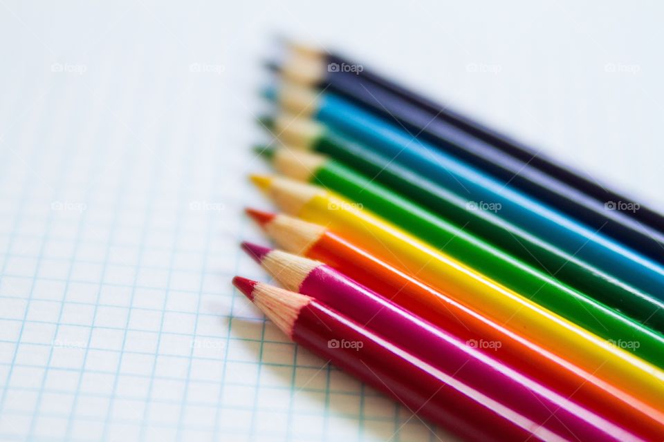 Colored pencils lined up on graph paper