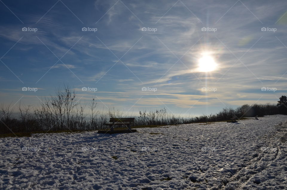 winter landscape on a high plain with its snow and sun in the shining clouds