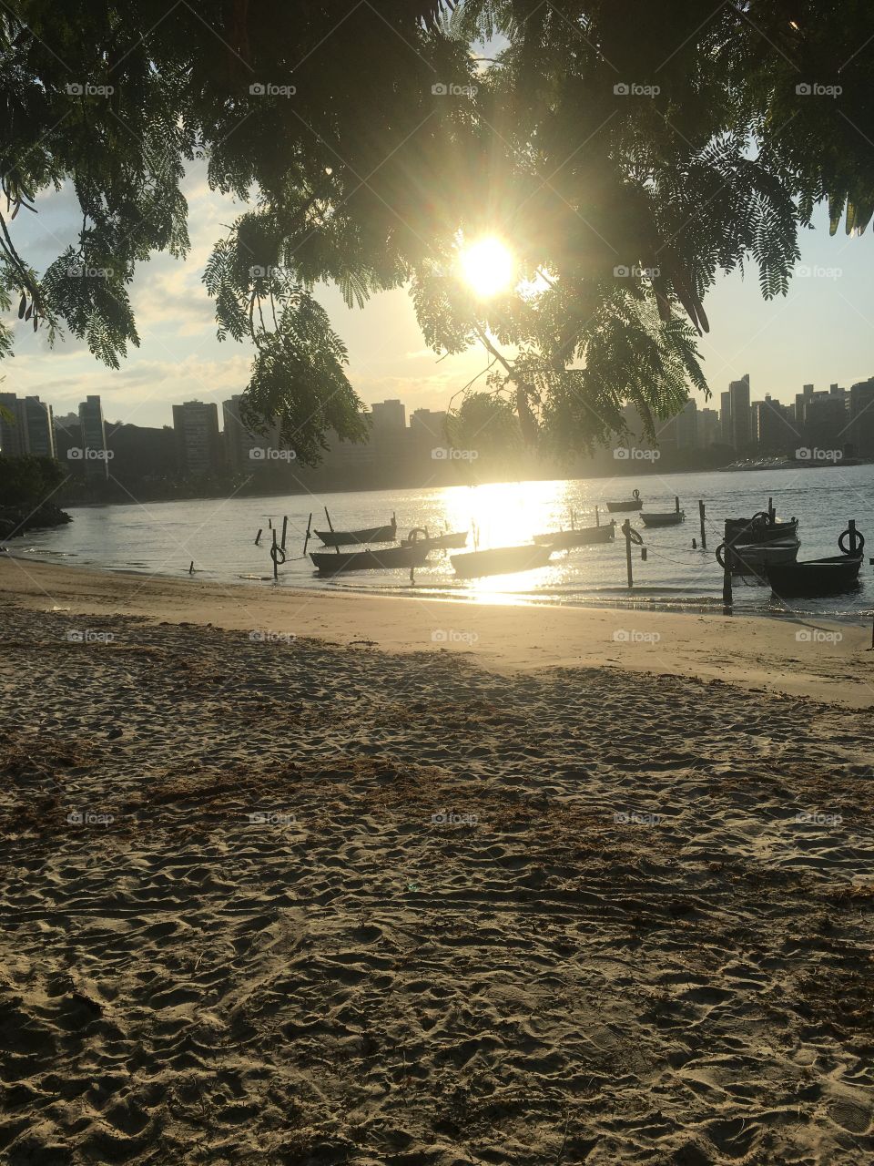 Por do sol em frente aos barquinhos na praia