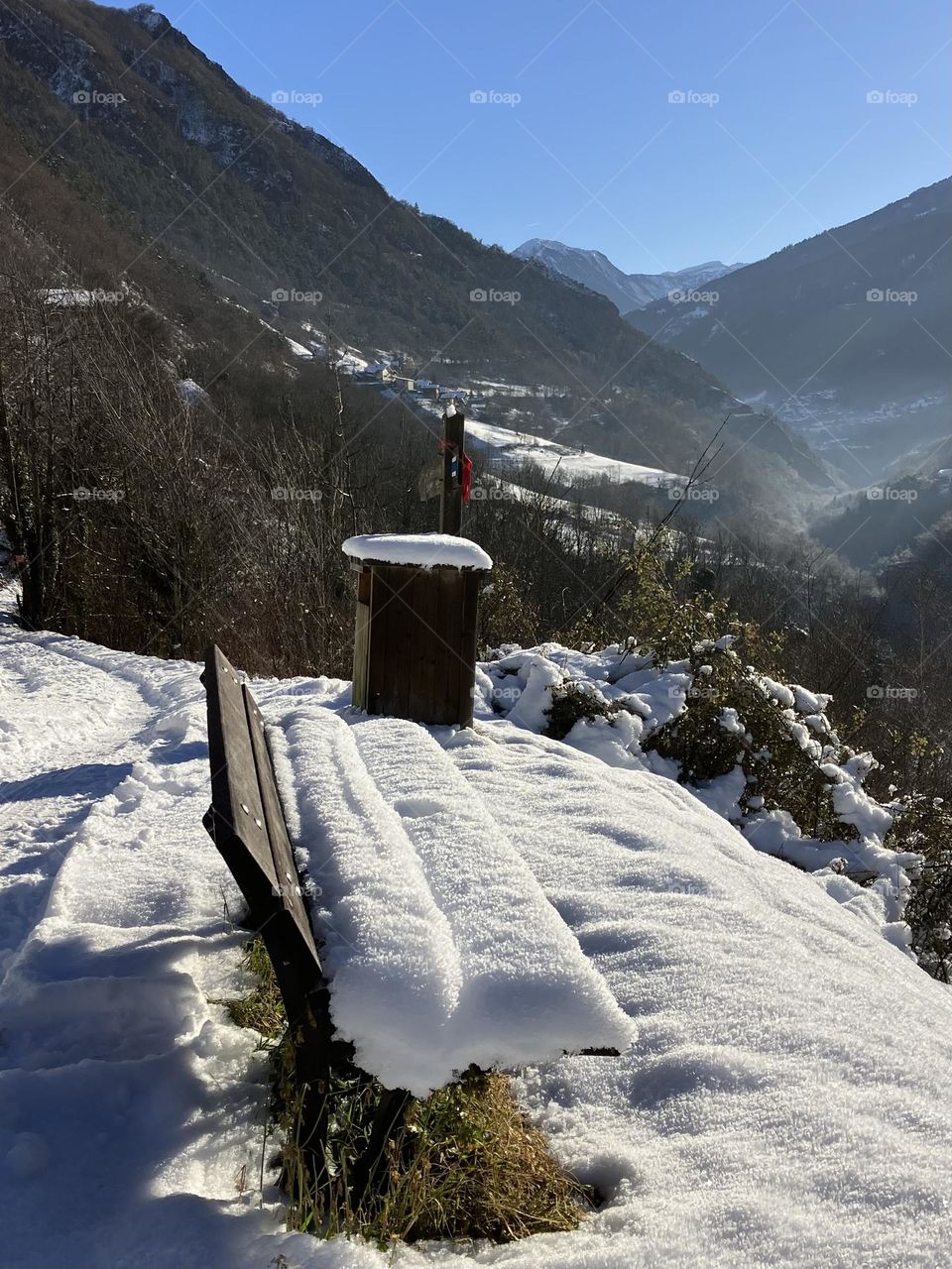 Snowy bench over the valley