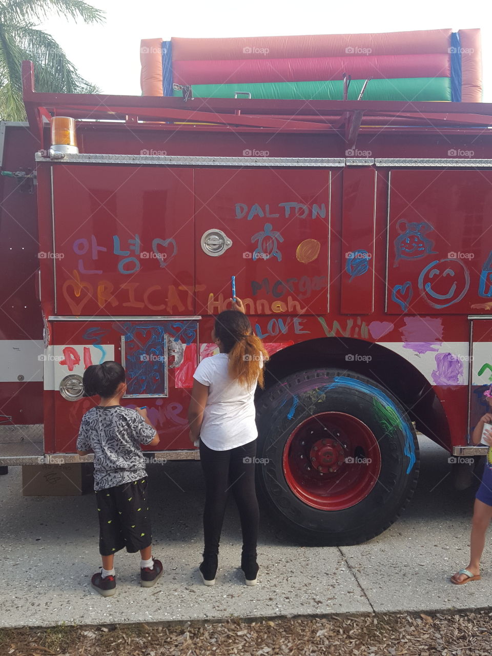 the kids were painting the fire trucks as part of the fun before the reopening of school.