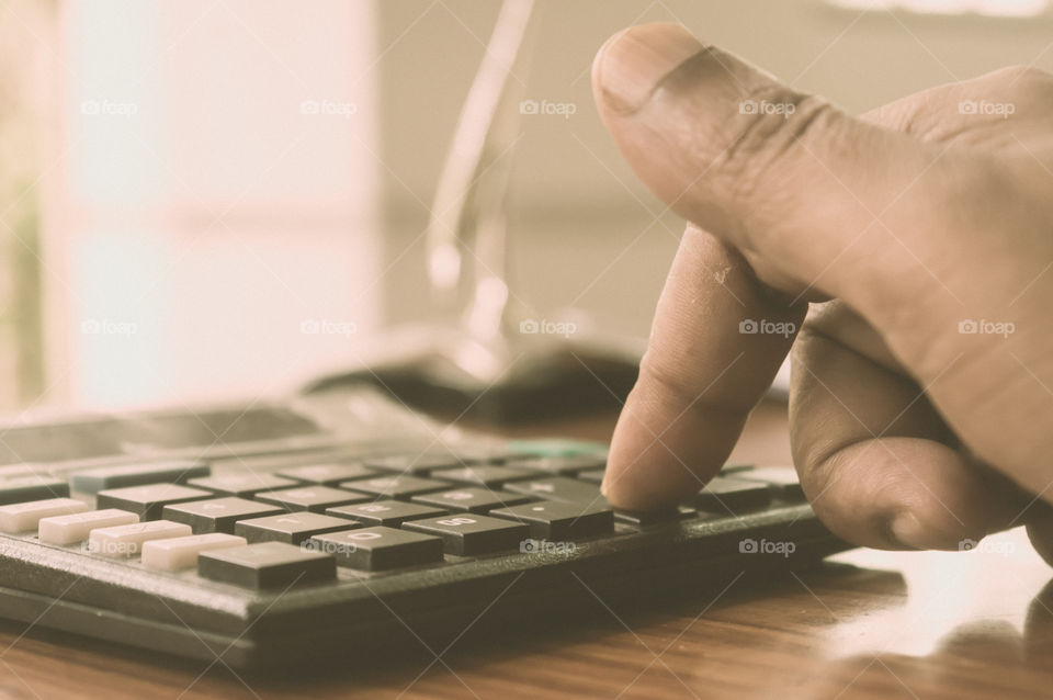 Close up of Press the right button. Calculator with finger. Fingers pressing the buttons of calculator. A businessman typing hand calculating numbers. Counting on vintage background isolated.