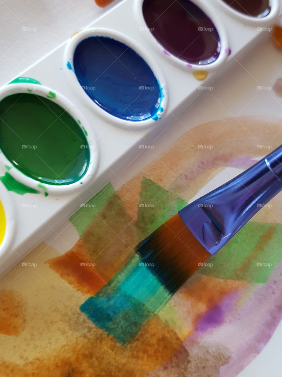 Close-up of watercolors and paintbrush