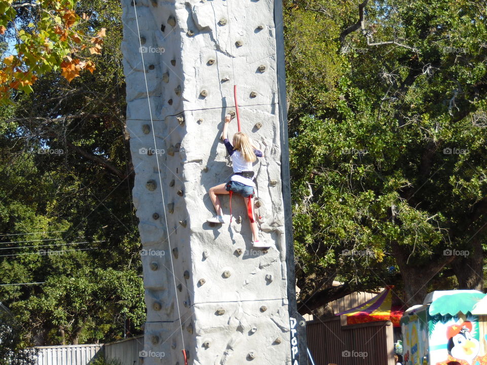 rock climber. This is a picture of a girl climbing up a rock wall.