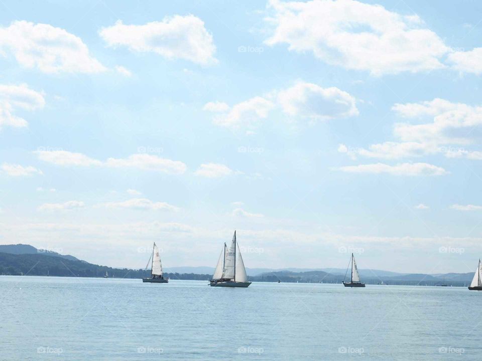 Sailing boats in the light blue lake with bright colours.