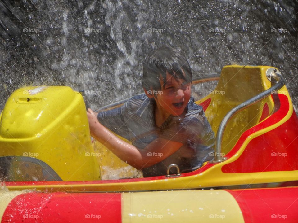 Boy In Bumper Boat Playing In Water