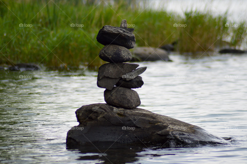 Cairn in lake with grass in background