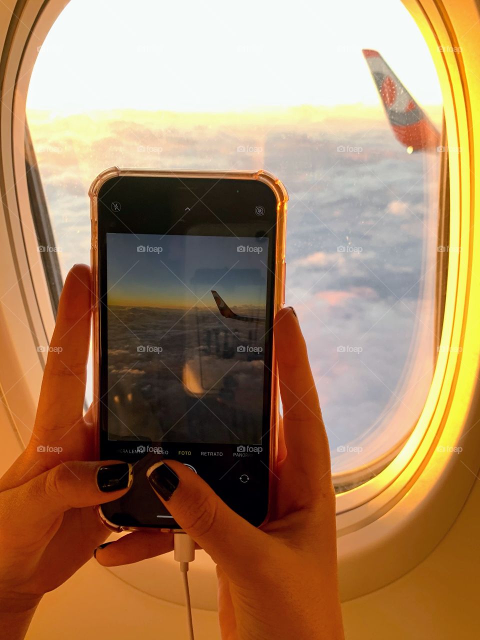 Girl photographing from airplane window