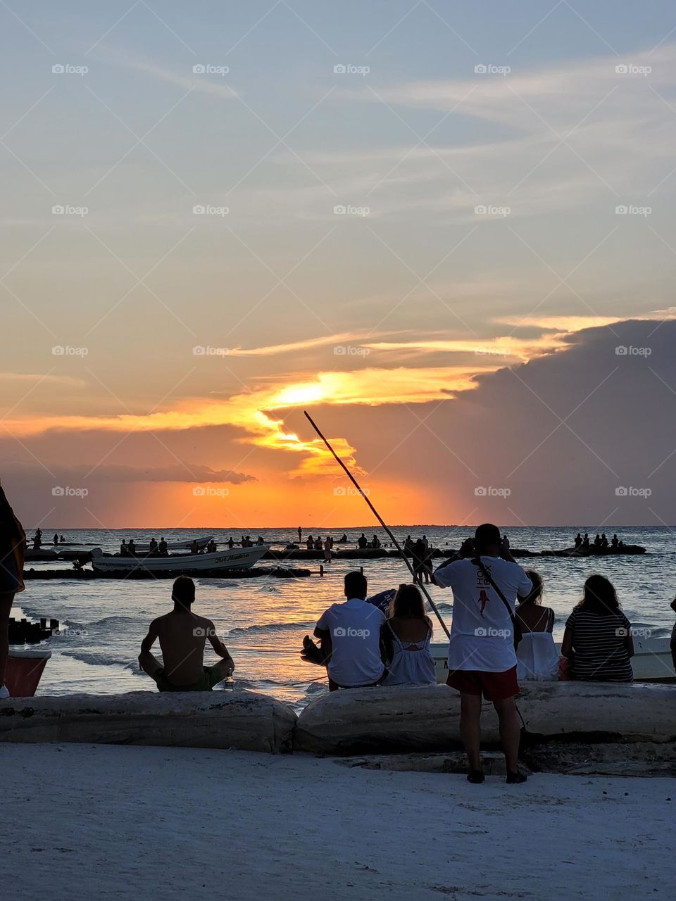 gente observando el atardecer en la playa